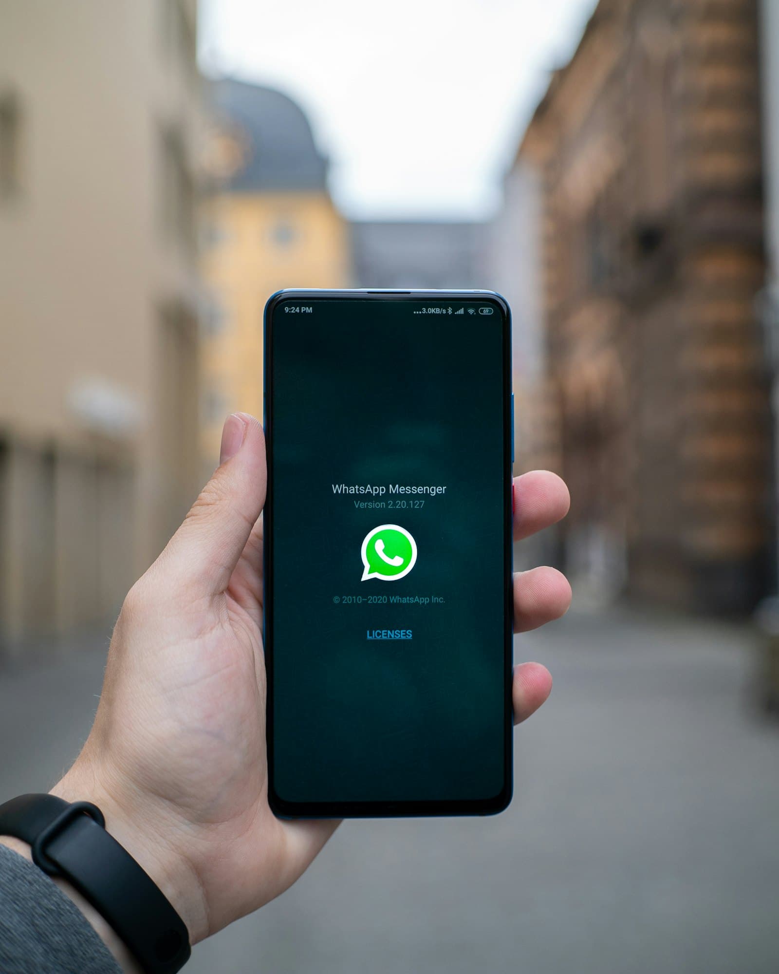 Une main tient un téléphone sur lequel WhatsApp vient de s'ouvrir.