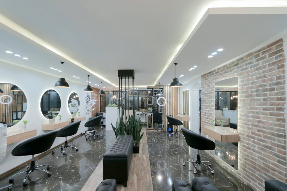 Un salon de coiffure vide, fauteuils devant les miroirs.